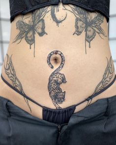 a woman's lower back with tattoos on her stomach and the bottom half of her body