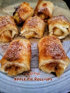 apple pie roll - ups on a plate with powdered sugar