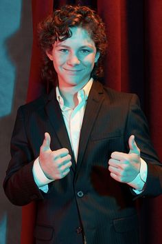 a man in a suit giving the thumbs up sign