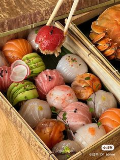 two boxes filled with assorted sushi and chopsticks on top of a wooden table