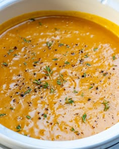 a white bowl filled with soup and garnished with herbs