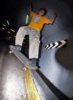 a young man riding a skateboard up the side of a cement ramp at night