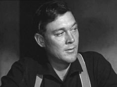 black and white photo of a man with an apron looking off to the side in front of him