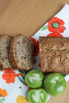 two slices of bread sitting on top of a table next to green peppers and tomatoes