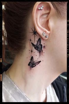 a woman's neck with two butterflies tattoo on her left side behind the ear