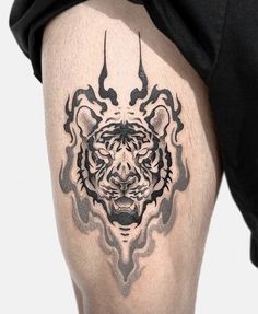 a man's thigh with a tiger tattoo on it