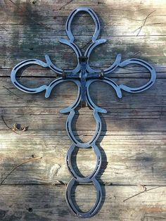 an iron cross is hanging on the side of a wooden wall