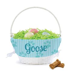 a basket filled with eggs and grass next to a dog bone on a white background