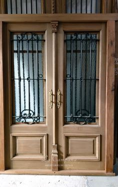 two wooden doors with metal bars on them