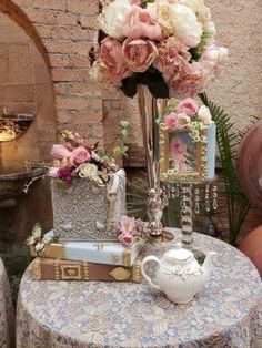 a table topped with a vase filled with flowers next to a mirror and other items