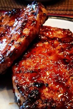 two pieces of meat sitting on top of a white plate