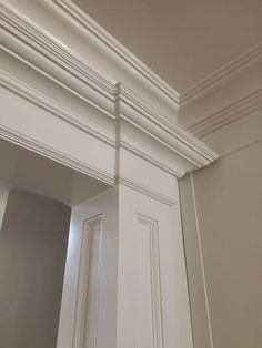 the corner of a room with white paint and molding on the wall above it