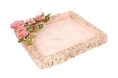 pink flowers are placed on the edge of a wicker tray that is made out of straw