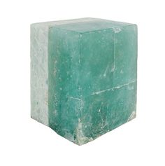 a green marble block sitting on top of a white floor