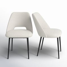 two white chairs sitting next to each other on top of a white floor covered in black legs