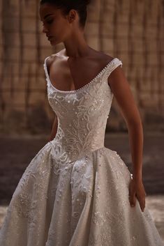 a woman in a white wedding dress standing outside