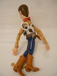 a toy doll wearing cowboy boots and a bandana