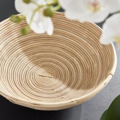 a close up of a bowl with flowers in the background