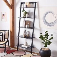 a living room with a black ladder shelf next to a potted plant