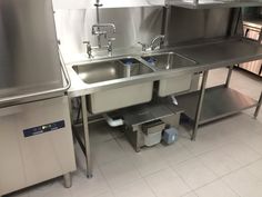 a stainless steel kitchen with two sinks and no faucets on the counter top