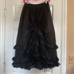 New With Tags Purchased In 2011 For A Halloween Costume Party And Never Wore It’s Been In Storage Ever Since Rq-Bl Red Queens Black Legion Polyester Multi Tier Skirt Pull On Style Elastic Waist High Low Hem Size F Will Fit One Size It’s All Size Small To Large Measurements Waist 12” Flat Across And 18” Max Stretched Length 29” Height 34” Low In Preowned Condition Black Costume Skirt With Attached Cancan, Black Skirt With Attached Cancan For Costume, Costume Black Skirt With Ruffles, Costume Black Ruffle Skirt, Costume Black Ruffled Skirt, Costume Skirt With Ruffles In Black, Black Ruffled Skirt For Costume, Gothic Black Skirt With Attached Cancan, Black Skirt With Attached Cancan For Costume Party