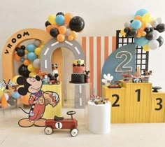 a mickey mouse birthday party with balloons and decorations