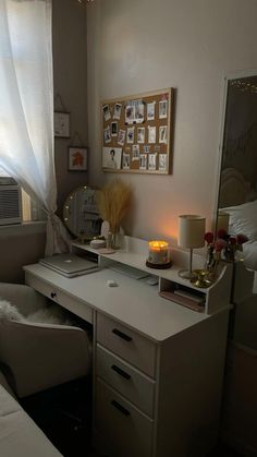 a bedroom with a desk, chair and pictures on the wall above it in front of a window