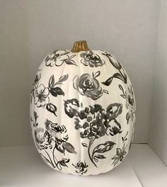 a white pumpkin decorated with black and white flowers