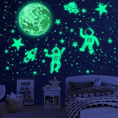 a bedroom with glow in the dark wallpaper and space themed decals on the walls