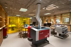 an office with many computers and desks in the room, including a printer machine