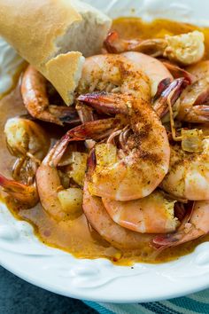 a white plate topped with shrimp and bread