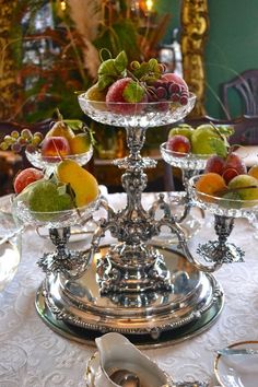 a silver plate topped with fruit on top of a table