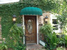 a wooden door with a green awning over it's entrance to a house