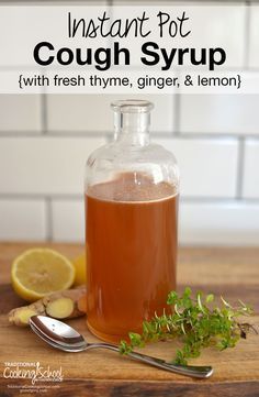 a bottle of cough syrup sitting on top of a wooden table next to lemons