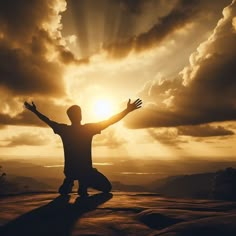 a man standing on top of a mountain with his arms wide open