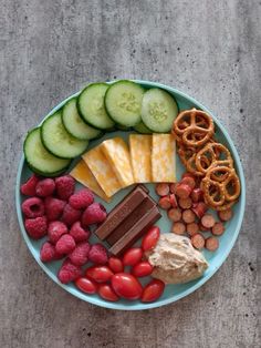 a plate filled with fruits, vegetables and pretzels on top of a table