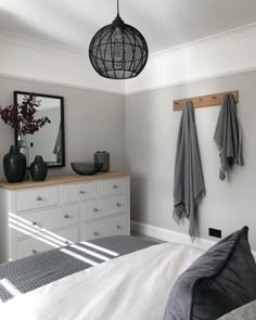 a bedroom with a bed, dresser and mirror