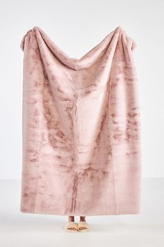 a pink blanket draped over the top of someone's feet