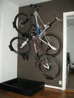 there is a bike hanging on the wall in the room with it's wheels up