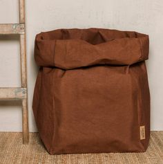 a brown bag sitting on the floor next to a ladder