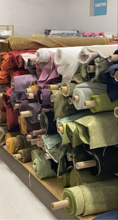 many different colored ties are on display in a store or showroom, with one being rolled up and the other is untied