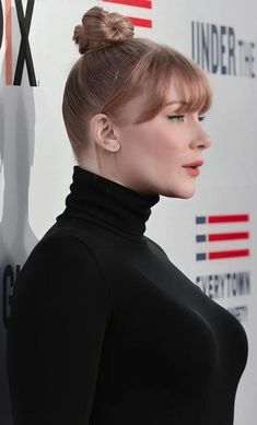 a close up of a person with a bun in her hair and an undercut