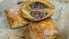 three pastries sitting on top of a piece of wax paper covered in chocolate filling