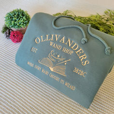 a blue bag sitting on top of a bed next to a small potted plant