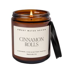 the cinnamon rolls candle is in a glass jar with a black lid and a white label that reads, sweet water decor