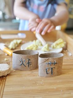 two cups with writing on them are sitting on a table next to cookies and other items