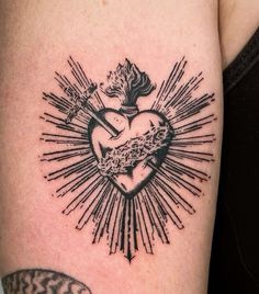 a black and white heart tattoo on the arm