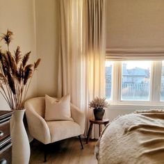 a bedroom with a bed, chair and window in it's centerpieces