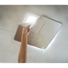 a person is lighting up the ceiling with a light on it's side,