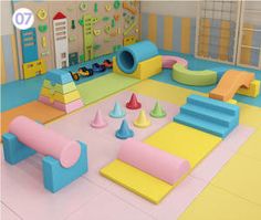 an indoor play area for children with soft foams and plastic cones on the floor